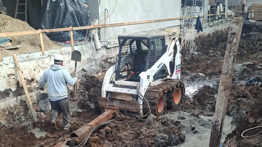 Mini carregadeira Bobcat com perfuratriz de estacas em obra em Curitiba