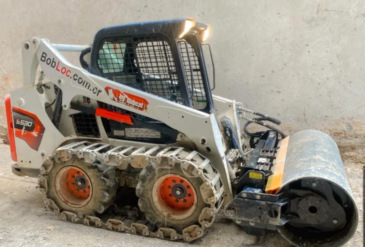 Bobcat com esteira de aço e rolo compactador para locação em Curitiba — Bob Loc