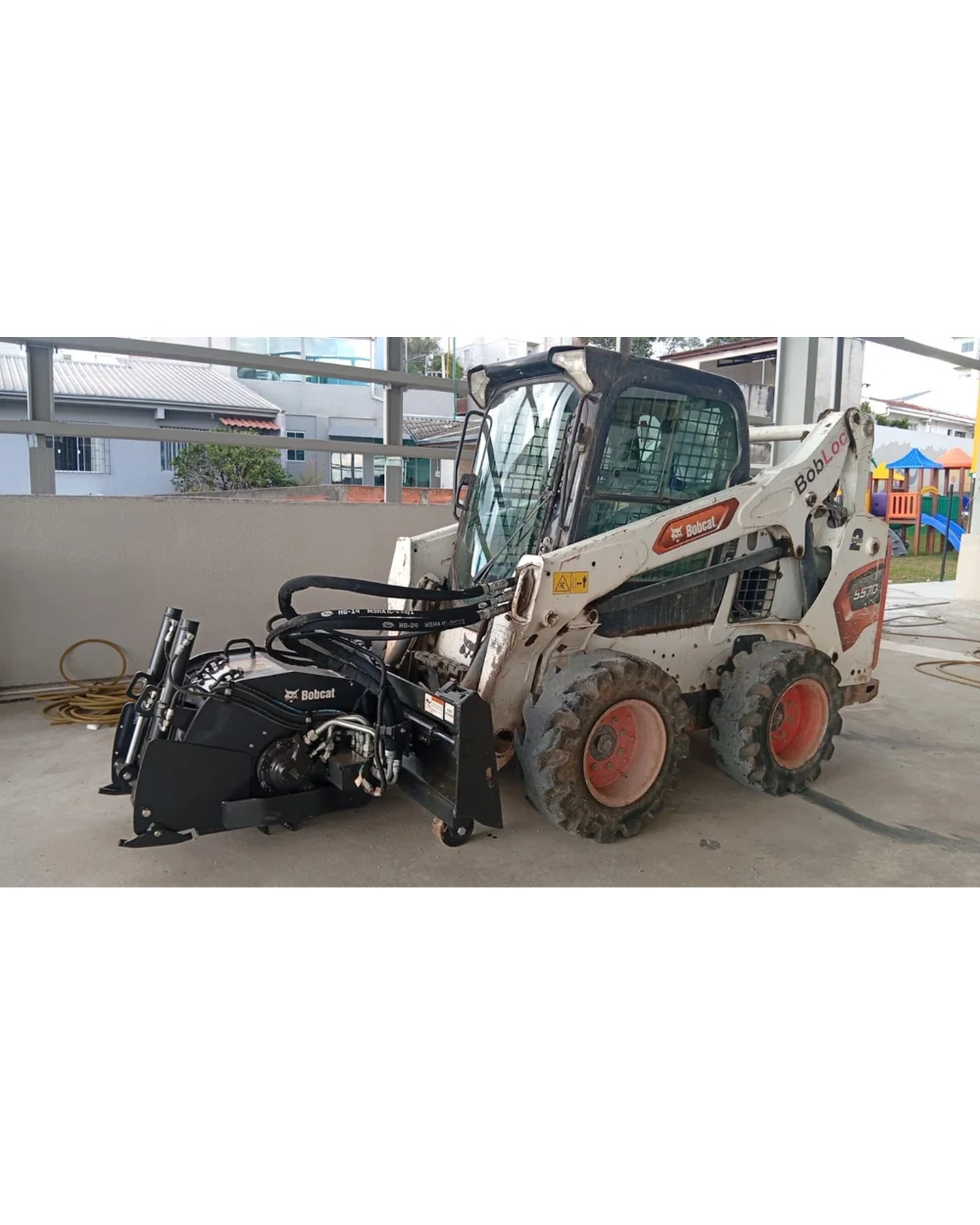 Fresadora de asfalto acoplada à Bobcat fazendo fresagem em Curitiba